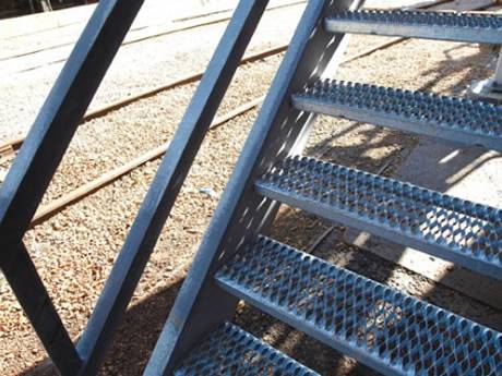 Heavy duty diamond opening plank grating stair treads for a railway station.